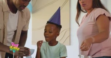 Çeşitli aileler doğum gününü evde kek ve parti şapkalarıyla kutluyor. Kutlama, doğum günü partisi, birliktelik, mutluluk, şenlik, neşe