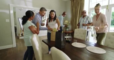 Bir grup kıdemli arkadaş evde kutlama yapıyor, hediyeleri değiş tokuş ediyor ve birlikte içkinin tadını çıkarıyorlar. Kutlama, hediye, parti, arkadaşlık, birliktelik, sosyalleşme.