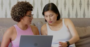 Çeşitli bayan arkadaşlar kanepede dizüstü bilgisayar ekranını göstererek akıllı telefon görüşmeleri yapıyorlar. İşbirliği, tartışma, rahatlık, teknoloji, gündelik, bağlantı, modern