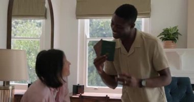 Siyah adam ve Asyalı kadın pasaport, güneş gözlüğü, şort ve kucaklaşmayla seyahat için hazırlanıyorlar. Romantizm, toplanma, seyahat, günlük, yaşam tarzı, neşeli, rahat