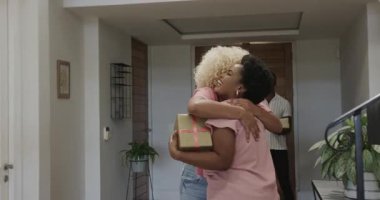 Çeşitli arkadaşlar birbirlerini kucaklayarak ve gülümseyerek selamlıyorlar. Arkadaşlık, birliktelik, mutluluk, bağlantı, sevgi, bağ