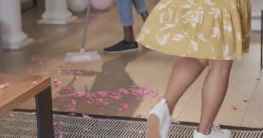 Adam evde yerleri süpürüyor, partiden sonra temizlik yapıyor. Ev işleri, hijyen, ev işleri, temizlik, ev işleri, bakım.