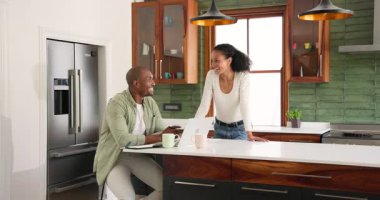 Mutfaktaki çeşitli çiftler başarıyı belgeler ve dizüstü bilgisayarla kutluyorlar. Memleketlerinde sevinçle gülümsüyorlar. İşbirliği, takım çalışması, kutlama, başarı, mutluluk, başarı