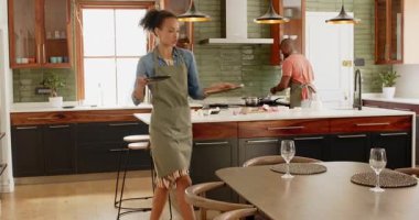 Çeşitli çiftler modern mutfakta birlikte yemek pişiriyor, evde neşe ve takım çalışması ile yemek hazırlıyorlar. Aşçılık, yaşam tarzı, bağlılık, yemek hazırlama, ortaklık, yerli