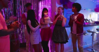 Çeşitli arkadaşlar eve doğum günü pastası getiriyor misafir mumları üflerken tezahürat yapıyorlar. Kutlama, dostluk, şenlik, parti, neşe, dostluk, dekorasyon