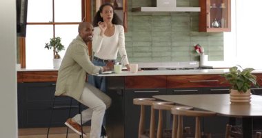 Mutfaktaki çeşitli çiftler kahve içerken dokümanları tartışırken keyifli anları paylaşıyorlar. Evrak işleri, tartışma, sohbet, sabah, birliktelik, ilişki