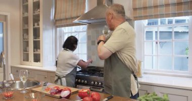 Son sınıf çifti mutfakta birlikte yemek pişiriyor, şarabın tadını çıkarıyor ve evde yemek hazırlıyor. Mutfak, hazırlık, yaşam tarzı, gurme