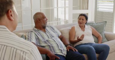 Kadın ve erkek kanepede oturup ciddi ciddi evlerinde sohbet ediyorlar. Çeşitlilik, iletişim, ilişki, çift, diyalog, duygular