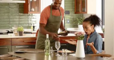 Mutfakta önlük takan adam, evde, masada şarapla yemek pişirmeye hazırlanıyor. Hazırlık, aşçılık, yaşam tarzı, gurme