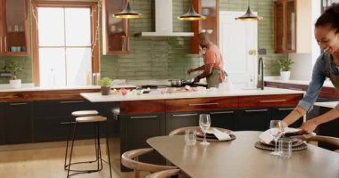 Çeşitli çiftler birlikte yemek hazırlıyor, sofra kuruyor ve modern mutfakta yemek pişiriyor. yerli, yaşam tarzı, aşçılık, takım çalışması, ev, yemek hazırlama