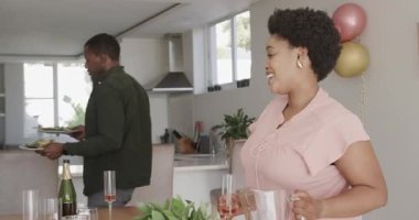 Mutfakta şampanya ve aperatiflerle kutlamaya hazırlanan bir adam var. Yemek, şenlik, içki, parti, şef, içecek