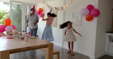 Çeşitli aileler dekore edilmiş odada kutlama yapıyor, evde pasta ve konfeti yiyorlar. Kutlama, aile, eğlence, parti, dekorasyon, birliktelik, mutluluk