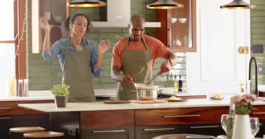 Çeşitli çiftler modern mutfakta birlikte yemek pişiriyor, evde odaklanarak ve takım çalışması yaparak yemek hazırlıyorlar. Mutfak, ev, ev hayatı, hazırlık, ortaklık, mutfak