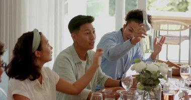 Çeşitli arkadaşlar konuşmacıyı alkışlıyor, yorumları paketliyor, masada şarap şişesini tost yapmak için uzatıyor. Kutlama, yoldaşlık, rahatlık, neşe, yaşam tarzı, sıcaklık, sosyal...