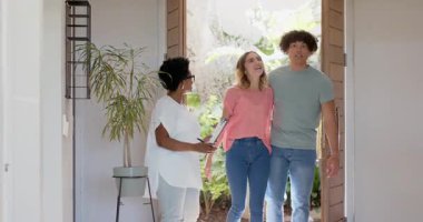 Modern bir evde genç, çeşitli çiftler gülümsüyor ve emlakçıyla yürüyor. yeni ev, toplantı, tartışma, tur, mülk, konut