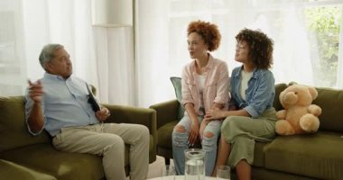 Yaşlı adam, evdeki yeşil kanepede özenli eşcinsel lezbiyen çift ile tartışıyor. Konuşma, tartışma, çeşitlilik, destek, ilişki, yaşam tarzı