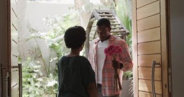 Çeşitli çiftler çiçek değiş tokuşu yapıyor ve ev girişinde içten bir gülümseme sergiliyorlar. Aşk, hediye, ilişki, sevgi, mutluluk, aşk