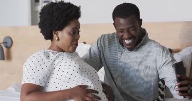 Video sohbetleri, koltukta oturan farklı çiftler evde selfie çekerken gülümsüyorlar. Beraberlik, mutluluk, teknoloji, bağlanma, boş zaman, yaşam tarzı