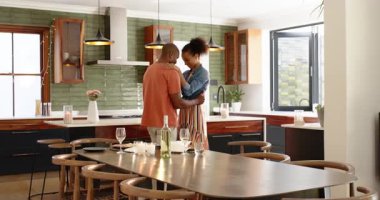 Modern mutfakta kucaklaşan farklı çiftler, evde birlikte neşeli bir anı kutluyorlar. Aşk, mutluluk, yaşam tarzı, kucak, aşk