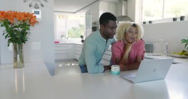 Modern mutfakta, evde bilgisayar başında sohbet ederken arkadaşlarımız başarıyı kutluyorlar. Kutlama, arkadaşlık, çevrimiçi, dijital iletişim, teknoloji, modern yaşam tarzı