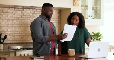 Yetişkin çiftler mutfakta dizüstü bilgisayar ve kahve fincanıyla belgeleri gözden geçiriyorlar. Yaşlılar, emekliler, finans, planlama, ev, yaşam tarzı