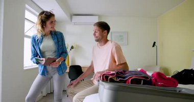 Yatak odasında bavul hazırlayan çift, evde heyecanlı bir tatil için hazırlanıyor. Seyahat, bagaj, hazırlık, macera, yolculuk, kaçış