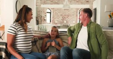 Çeşitli aile mektupları ultrason haberlerini gösteriyor, kızı koltukta göbeğine dokunuyor. Aile, hamilelik, birleşme, bağlantı, kutlama, sıcaklık, ev