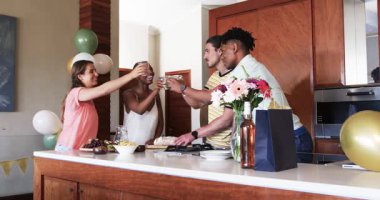 Mutfakta kutlama, arkadaşlar içki ve atıştırmalıklar, neşeli sohbetler. Kutlama, arkadaşlık, parti, toplanma, mutluluk