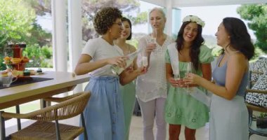 Çeşitli bayan arkadaşlar gelin olmayı kutluyorlar şampanya kadehlerini terasa doldurup kadeh kaldırıyorlar. Kutlama, zarafet, sofistike, arkadaşlık, açık hava, lüks, canlı