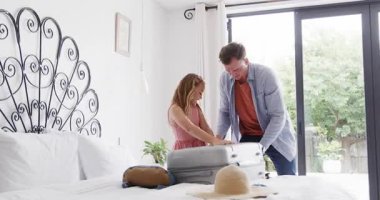 Anne çeşitli ailelerin bavullarını açarken, güneş şapkası takarken, bahçeye girerken. Aile, seyahat, valiz, valiz, açık hava, boş zaman, yaşam tarzı