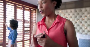 Farklı kadın çiftler evde yatakta oturuyor, gülümsüyor ve arkadaşlıklarından keyif alıyorlar. Arkadaşlık, birliktelik, mutluluk, bağlanma, yaşam tarzı, rahatlık