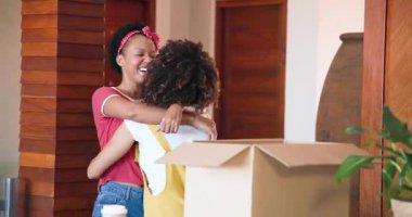 Yeni evdeki kutuları açıyor, lezbiyen çift sevinçle kucaklaşıyor ve birlikte gülümsüyor. Taşınma, yeni başlangıçlar, taşınma, mutluluk