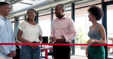 Çeşitli meslektaşlar modern ofiste kurdele kesme törenini kırmızı kurdeleyle kutluyorlar. Kutlama, takım çalışması, kilometre taşı, başarı, profesyonel, ofis, heyecan