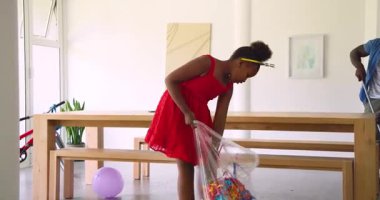 Annemin kurdeleleri vermesi Afro-Amerikalı kızların çantalara toplanmasına ve adamın yemek alanında paspas yapmasına neden oluyor. Kutlama, aile, dekor, takım çalışması, canlı, yerli, ev yapımı