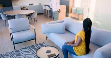 Afro-Amerikalı meslektaşlar eve giriyor, tabletle el sıkışıyor, kanepede projeyi tartışıyorlar. Profesyonel, gündelik, modern, işbirliği, iletişim, sosyal, iç