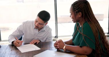 Afrika kökenli Amerikalı kadın ve genç adam kurdele kesme törenini olay yerinin içinde el sıkışarak kutluyorlar. Kutlama, ortaklık, başarı, tören, işbirliği, profesyonel, takım çalışması