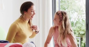 Anne ve kız günlük giysiler giyip çamaşırları sınıflandırıyor ve evde çamaşır yıkama becerileri öğreniyorlar. Aile, günlük rutin, yetiştirme, bağlama, aile içi, yaşam tarzı, samimi