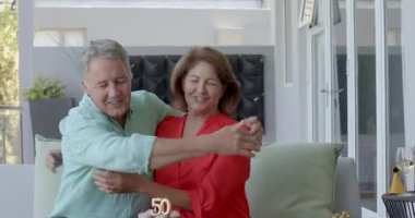 50. doğum gününü kutlarken, farklı yaşlı çiftler 50 mum pastasını paylaşıyor, balkonda şarap kızartıyorlar. Yıldönümü, arkadaşlık, açık hava salonu, kutlama, hassas an, sofistike, boş zaman.