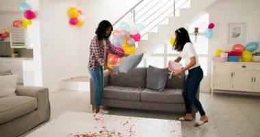 Oturma odasında süpürge ve faraşla konfeti süpüren çeşitli bayan arkadaşlar. Ev işleri, temizlik, takım çalışması, parti dekorasyonu, ev dekorasyonu, renkli, parlak