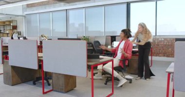 Çeşitli iş arkadaşları modern ofiste sandalyeyi itip masalar arasındaki neşeli anı kutluyorlar. Kutlama, takım çalışması, oyuncu, ofis, çevre, modern, mobilya