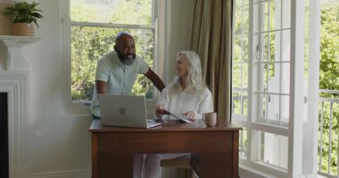 Üst düzey bir çift ofiste oturmuş akıllı telefon mesajlarını izliyor, kağıtları atıyor, kontrat imzalıyor. İşbirliği, mutluluk, başarı, modern, yaşam tarzı, profesyonellik, bağlantı