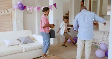 Kutlamaya hazırlanan Afro-Amerikan ailesi balonlarla evi dekore ediyor. Şenlik, dekorasyon, birliktelik, çok nesilli, neşeli, bağlanma