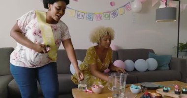 Bebek partisini kutlamak, farklı arkadaşların evde pankartlar ve balonlarla dekore etmesi. Kutlama, etkinlik, parti, arkadaşlık, annelik, mutluluk