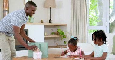 Kalemler, yeşil çanta ve hediyelerle modern yaşam evine yardım ve çizim yapan Afro-Amerikan aile. Aile, yaratıcılık, eğitim, modern, katılım, iç mekan, eğlence, doğa, etkinlik