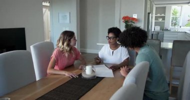 Orta yaşlı Afrikalı Amerikalı danışman, 20 'li yaşlardaki çiftlere evlerinde rehberlik eden belgeleri paylaşıyor. Profesyonel, danışma, tartışma, işbirliği, rehberlik, belgeler, samimiyet