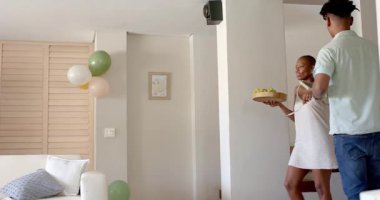 Arkadaşlar evde kutlama yapıyor, ellerinde şampanya ve hediyeler var, kutlama toplantılarının tadını çıkarıyorlar. Kutlama, parti, arkadaşlık, bayram, hediye verme.