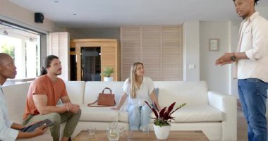 Arkadaşlar modern oturma odasında hareketli tartışmalar yapıyorlar, ilgi çekici ve özenli. Konuşma, arkadaşlık, iletişim, etkileşim, yaşam tarzı, bağ