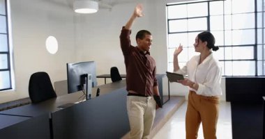 İş adamı ve iş kadını modern ofiste dizüstü bilgisayar kullanıyor ve tezahürat yapıyor. Teknoloji, iletişim, iş, iş ve ofis ortamı kavramı.