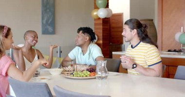 Arkadaşlar yemek masasının etrafında sohbet ve atıştırmalıklardan hoşlanıyorlar. Toplanma, sosyalleşme, arkadaşlık, konfor, eğlence