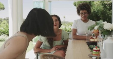 Bahçe masasının etrafında gülen kadın arkadaş olarak Koreli bir kadın kıdemli anekdotu davet ediyor. Arkadaşlık, dostluk, kutlama, gündelik, neşe, eğlence, sosyalleşme.